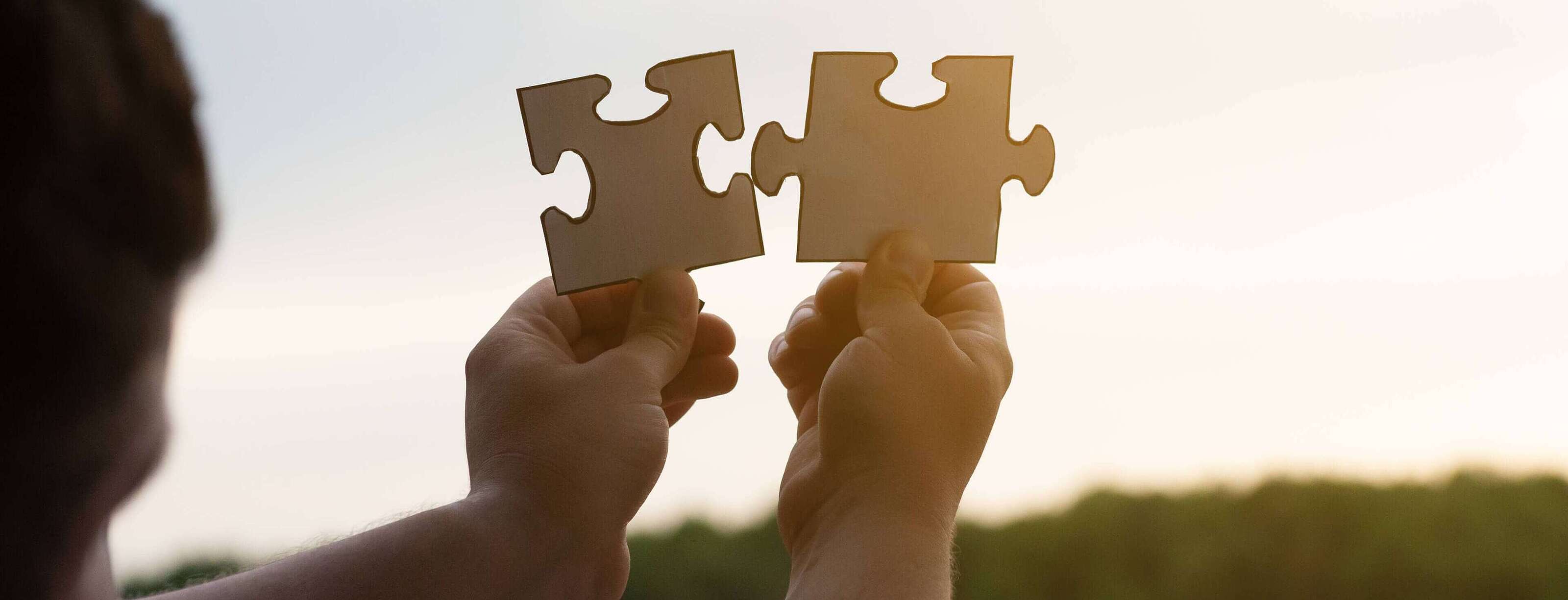 Qualität Person hebt mit seinen Händen Puzzle Stücke in den Himmel