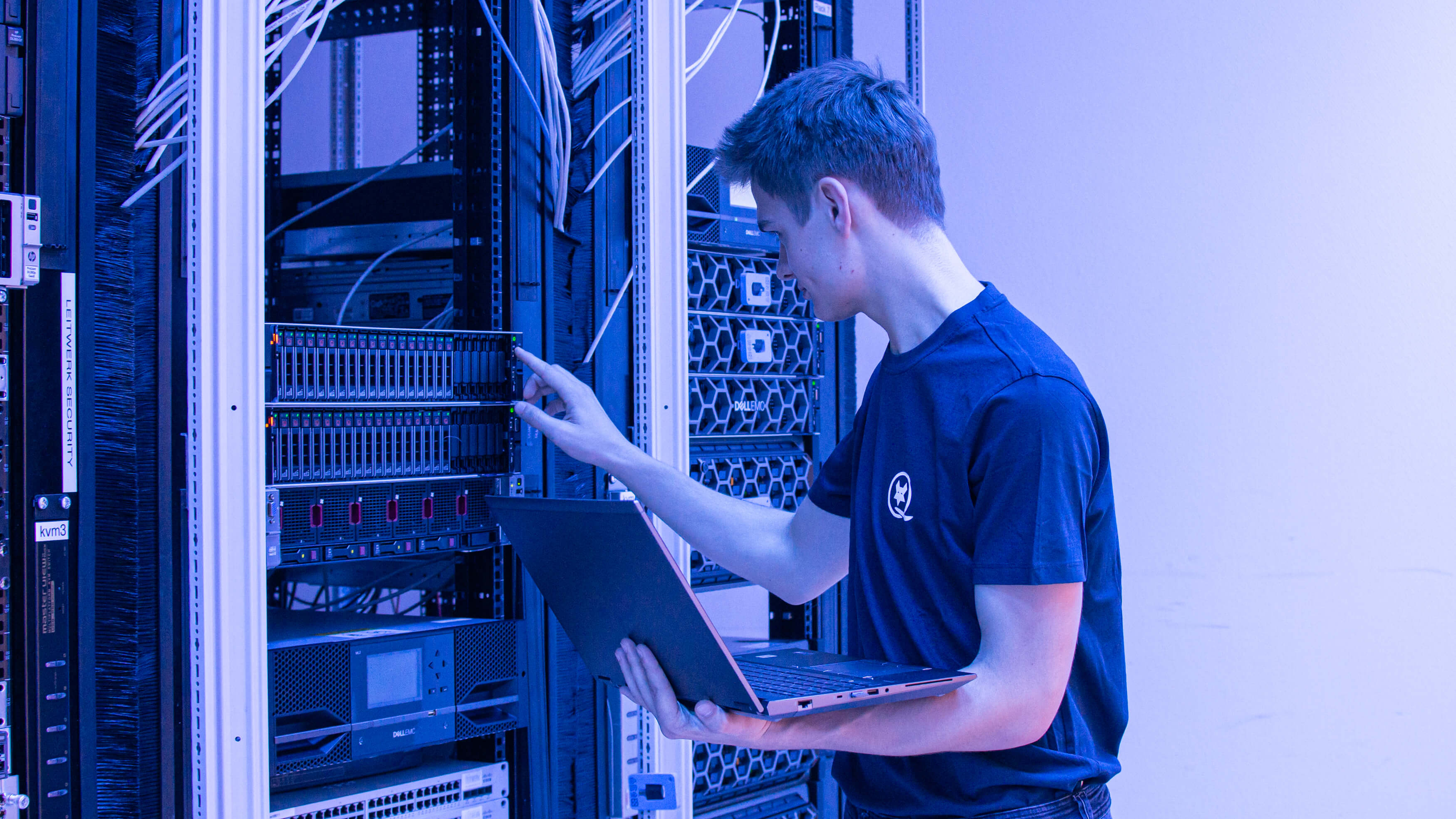 Mitarbeiter der LEITWERK AG untersucht einen Server und hat ein Laptop in der Hand