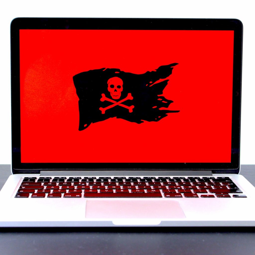 Aufgeklappter Laptop mit rotem Screen und einer Piraten Flagge