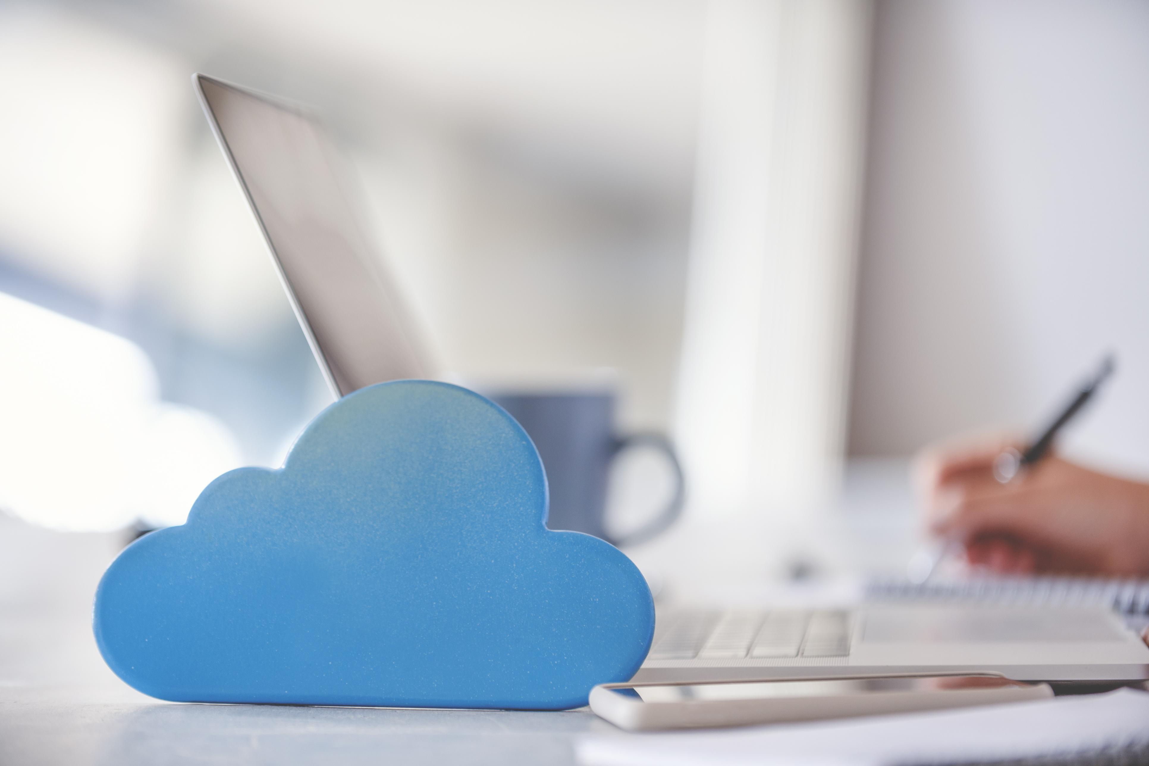Blaue Wolke steht auf Arbeitsplatz mit Notebook, Smartphone und Tasse Ihre Vorteile mit den Cloud-Lösungen von LEITWERK Blaue Wolke steht auf Arbeitsplatz mit Notebook, Smartphone und Tasse