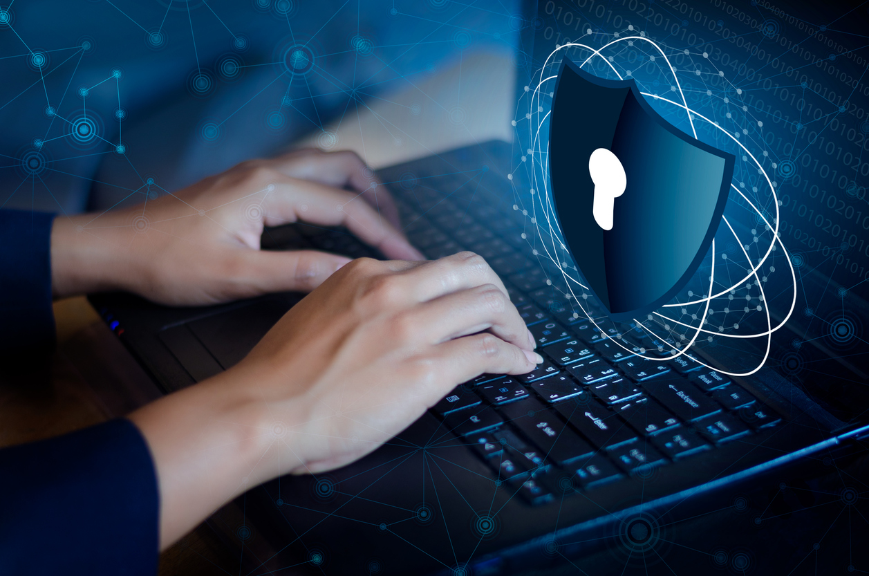 Sicherheit bei VPN Zwei Hände, tippend auf einer Laptoptastatur mit einem großen visuellen Verschluss Symbol