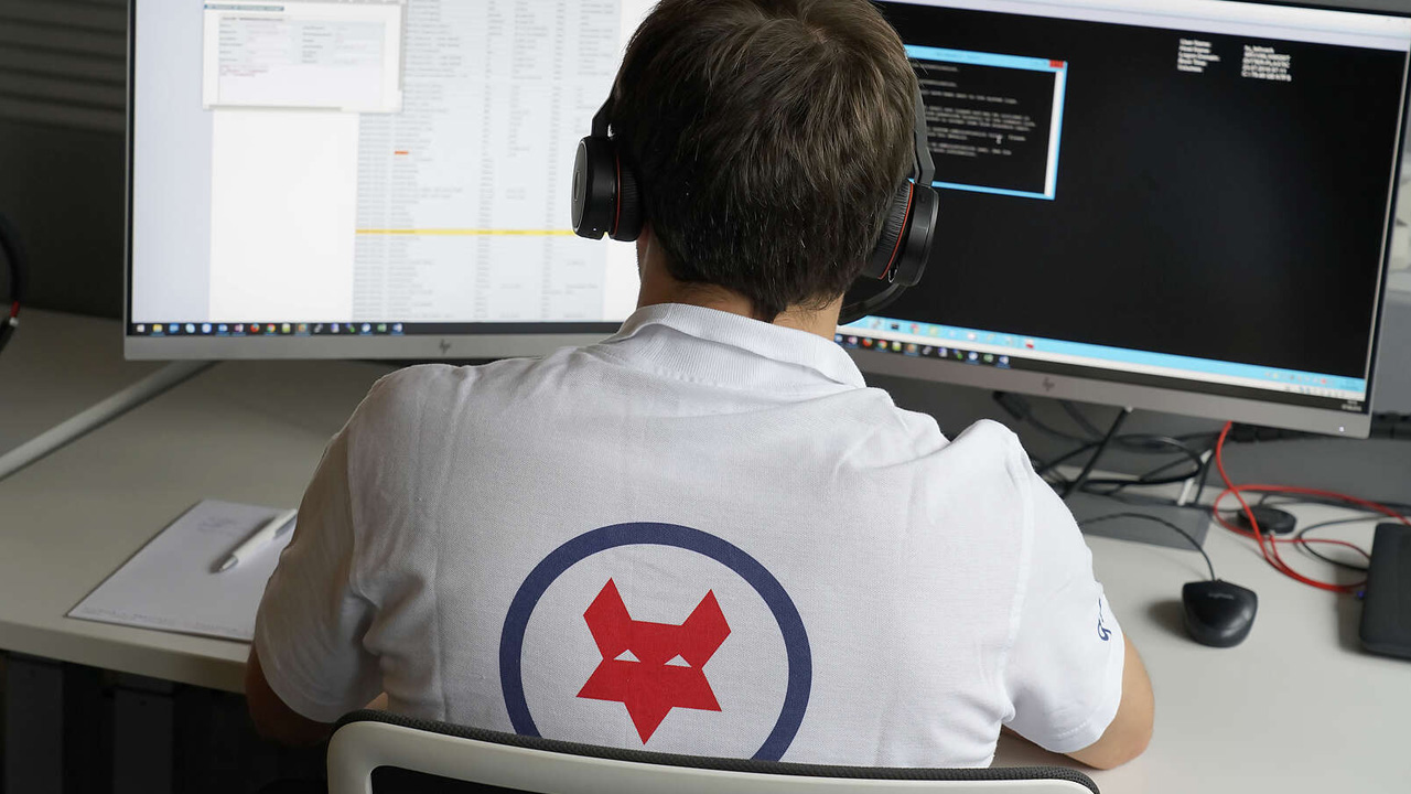 Service Desk Offenburg Service Desk Mitarbeiter am PC mit einem Q-FOX Polo