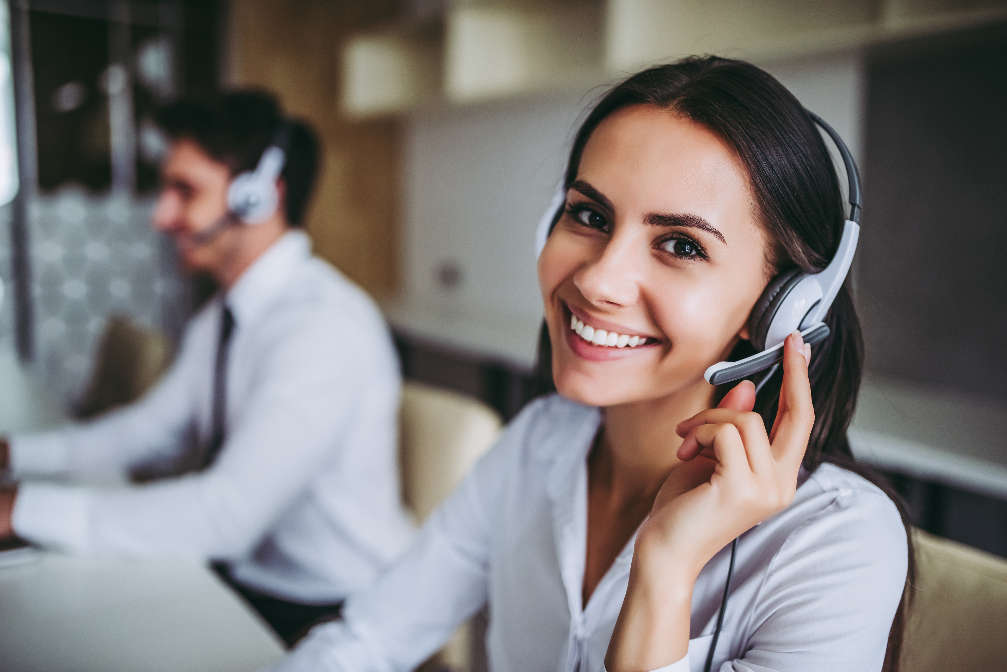 Zwei Personen mit Headset lächeln freundlich