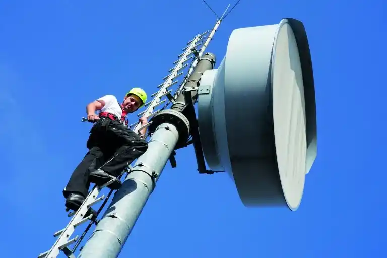 Anbindungen ans Internet über Richtfunk Antenne für Richtfunk, Mann auf Stufenleiter und blauen Himmel