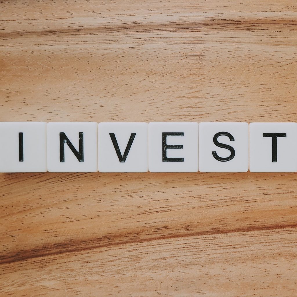 Weiße Bausteine zusammengelegt zu einem Schriftzug "Invest"