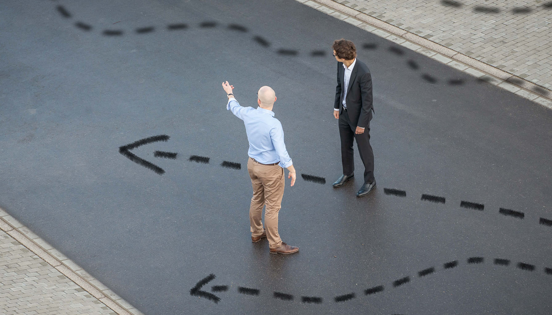 IT-Management Consultant weist einer anderen Person im Anzug die Richtung